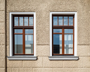 Two windows on a building with a clear blue sky.