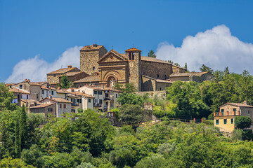 Obraz premium Historic Church of Santa Maria Assunta stands majestically in Panzano, a charming village in Tuscany's Chianti region under a blue sky