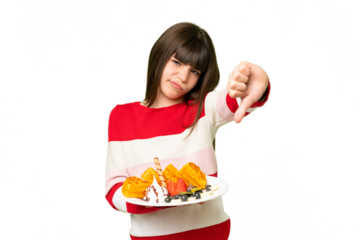Little girl holding waffles over isolated chroma key background showing thumb down with negative expression
