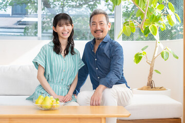 リビングでくつろぐミドルの夫婦