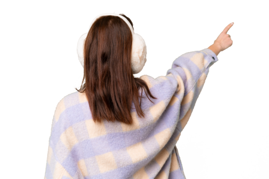 Young caucasian woman wearing winter muffs over isolated chroma key background pointing back with the index finger - Powered by Adobe