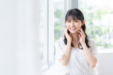 リビングでスキンケアをするミドルの女性