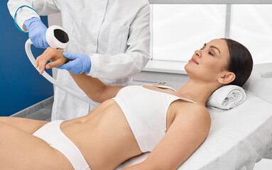 Photorejuvenation of woman arms using intense pulsed light IPL with beautician in cosmetology salon...
