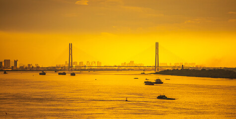 The Yangtze River and its shipping vessels, bathed in the glow of the setting sun, are located in...