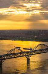 Fototapeta premium The Yangtze River and its shipping vessels, bathed in the glow of the setting sun, are located in Jiujiang, a historical and cultural ancient city in eastern Asia, Jiangxi Province, China.