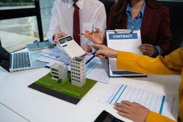 Real estate broker agent presenting and consult to customer to decision making sign insurance form agreement, home model, concerning mortgage loan offer in office