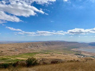 Scenic view of a mountain landscape and blue skies with clouds.