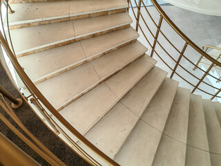 part of the curve steps indoor building with metal golden fence handrail. 