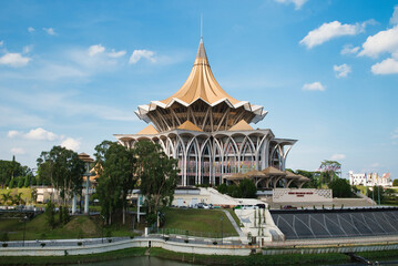 View from across the Sarawak River, the new Sarawak State Legislative Assembly building. The cross-section of the building is a golden pavilion and is shaped like a nine-pointed star. Kuching, Borneo 