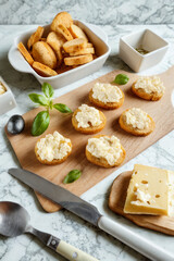 Appetizers with cheese and herbs on a wooden board