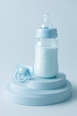 Fototapeta premium Baby bottle with milk and pacifier on a soft blue pedestal in a serene environment