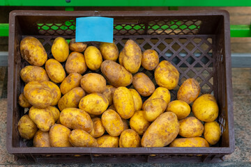 Vibrant yellow potatoes neatly arranged in a rustic brown basket at a local market