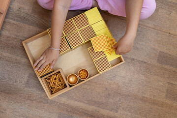 Montessori box with gold material for mathematics, numbers, decimal number system. Alternative education for learning mathematics, algebra, geometry, arithmetic.