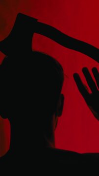 Silhouette of a man with an axe on his head on Halloween night