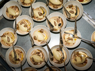 Petites assiettes gastronomiques de purée crémeuse à la truffe noire servies lors d’une soirée d’entreprise sur un rooftop à Paris, présentation élégante et raffinée.