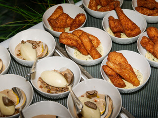 Assiettes gastronomiques individuelles servies lors d’une soirée d’entreprise sur un rooftop à Paris, associant truffe, purée crémeuse et aiguillettes panées dorées.