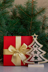 Red Christmas gift box with golden ribbon and wooden tree decoration