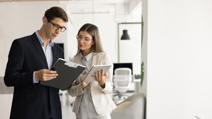 Two business colleagues checking reports of each other