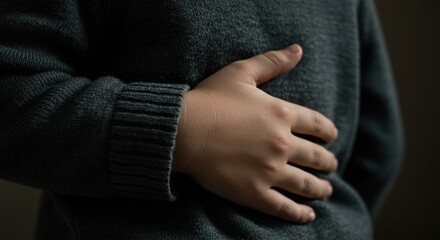 Child holding stomach in gray sweater with warm expression of kinship  