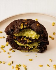Chocolate Cookie with Pistachio Cream Filling on White Plate with Bite Taken