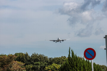 Jet plane landing with sun setting behind mountains