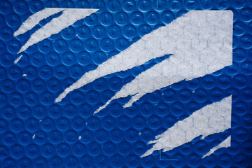 Blue bubble wrap package with aggressively peeled paper label sticker texture
