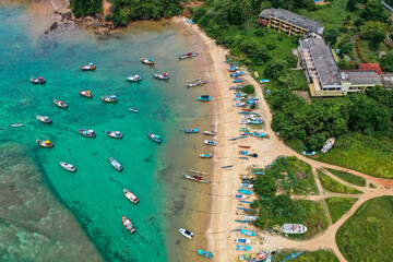 Traditional catamarans and fishing boats on Weligama Beach, Sri Lanka—drone shot of ocean, palms, and local culture