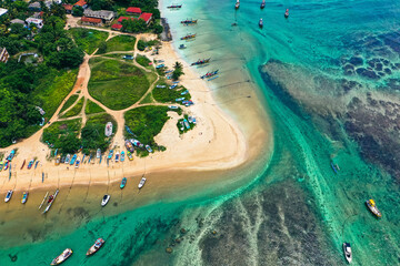 Drone view of Weligama Beach, Sri Lanka—traditional fishing boats, palm trees, and turquoise Indian Ocean waves