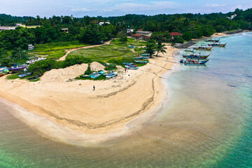 Drone view of Weligama Beach, Sri Lanka—traditional fishing boats, palm trees, and turquoise Indian Ocean waves