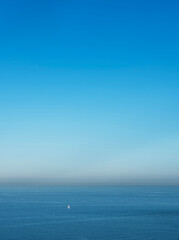 Obraz premium lonely sailing boat in channel near dover on early foggy morning