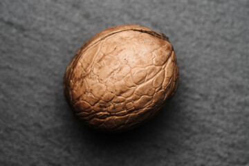 Obraz premium pojedynczy orzech włoski na ciemnym jednolitym tle