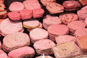 variety of sausages and cold cuts displayed in butcher shop counter