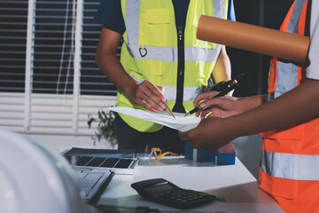 Closeup of team of industrial engineers meeting analyze machinery blueprints consult project on table in manufacturing factory. Working in manufacturing plant or production plant.