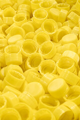 Lots of yellow plastic bottle caps