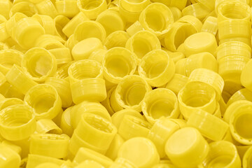 Lots of yellow plastic bottle caps