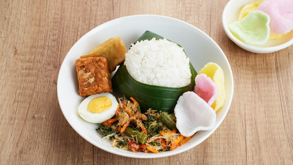 Nasi Gudangan, rice served with various vegetable with grated coconut seasoned and various side dishes. Indonesian food