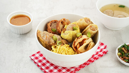 Bakso Malang, meatball soup with tofu, fried shumay, noodles and dumplings. Served with sambal and cucumber