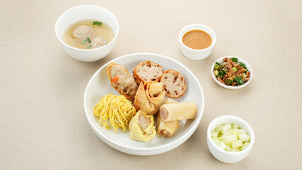Bakso Malang, meatball soup with tofu, fried shumay, noodles and dumplings. Served with sambal and cucumber