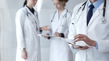 Healthcare professional using a digital tablet for patient data management, doctors collaborating on medical records, modern clinic team focusing on health technology - Powered by Adobe