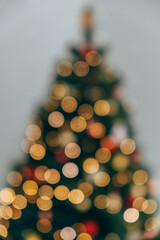 beautifully adorned blurred Christmas tree fills frame with warm golden lights, captivating ornaments, and joyful holiday spirit in cozy indoor setting during Christmas time. close up. vertical.
