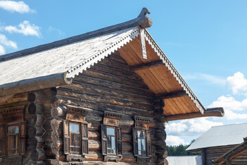 Roof of a russian wooden house featuring a carved ridge and decorative eaves