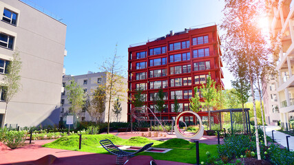 A residential building  by lush green trees and surrounded by  fresh vegetation on a clear sunny...