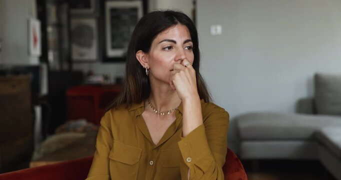 Bored pensive young Latin homeowner woman looking away