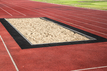 Long jump sand pit and track and field lines in stadium