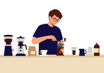 A man with glasses grinds coffee beans using a manual grinder, surrounded by coffee-making equipment on a counter.