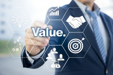 An executive's hand touches a virtual screen displaying the word value along with essential business concept icons for innovation, partnership, and goals.