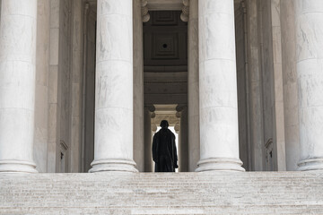  The bronze statue of Thomas Jefferson stands inside the memorial framed by tall marble columns.