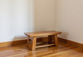 Fototapeta premium Elegant Wooden Bench with Minimalist Design in a Serene Corner of a Room Featuring Hardwood Floors and White Walls