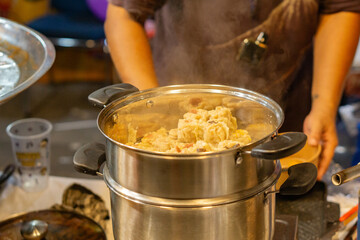 Delicious dim sum steaming in pot at Asian street food