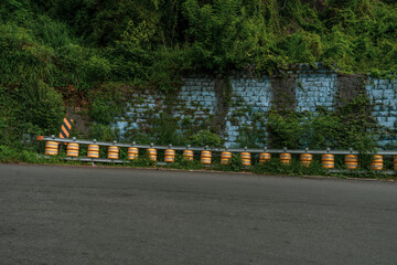 A row of barrels are lined up on the side of a road